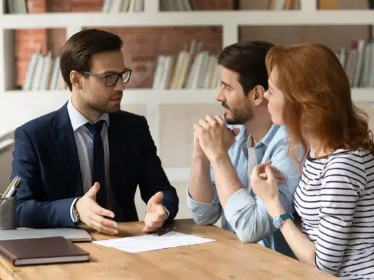 three people sitting at a desk