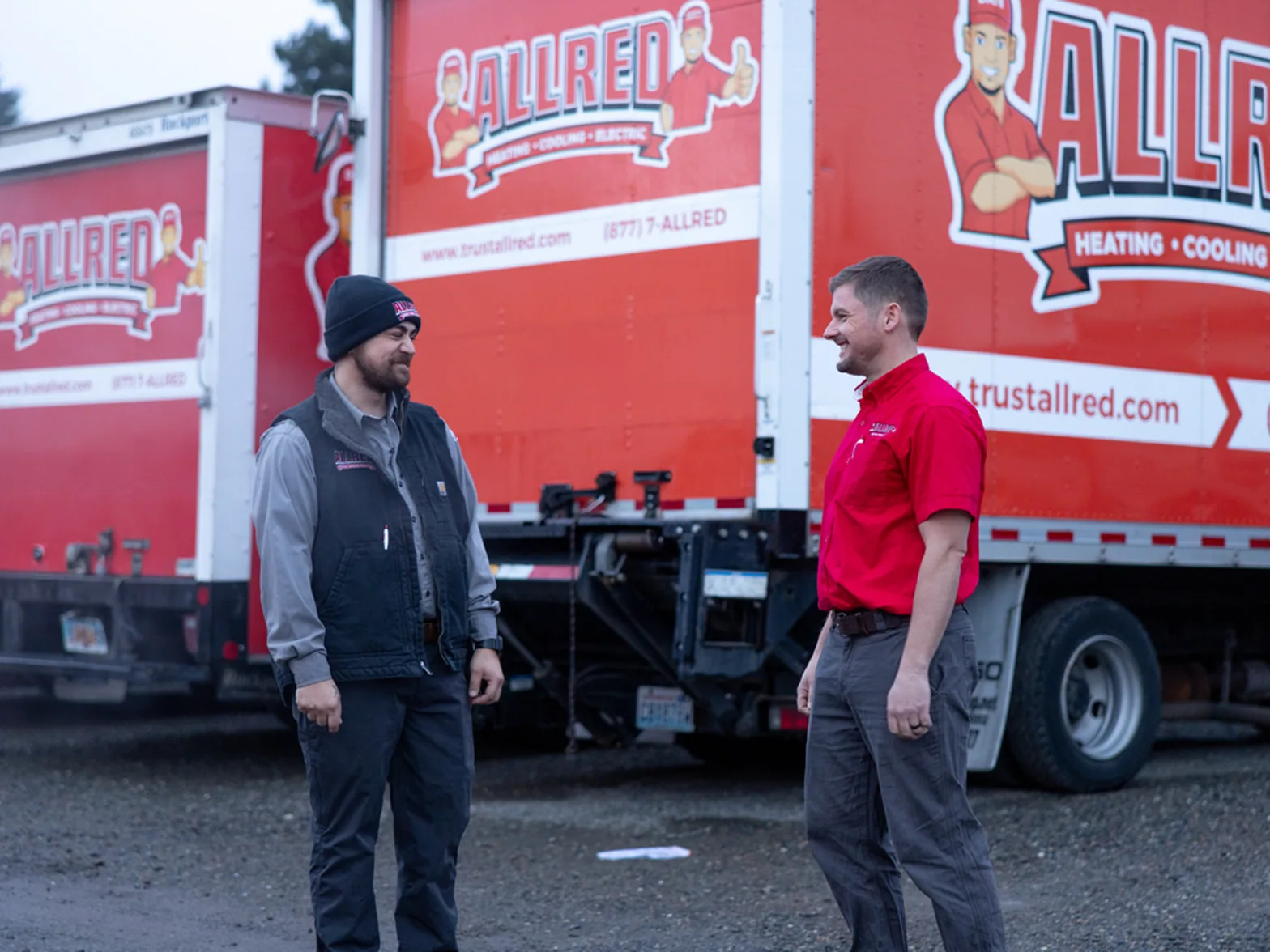 Allred team members on the job by branded service trucks
